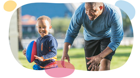 toddler boy running whit footbal while dad chases