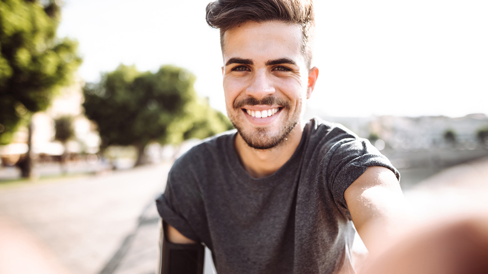 attractive young man smiling for a selfie.