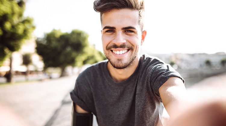 attractive young man smiling for a selfie.