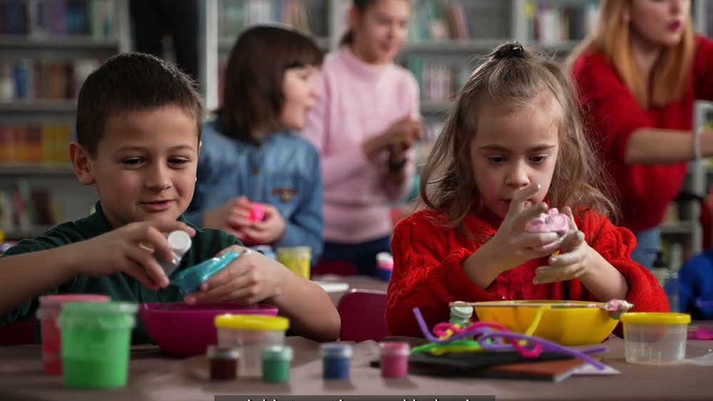 two children focusing on an activity at a table.