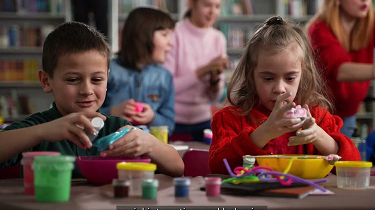 two children focusing on an activity at a table.