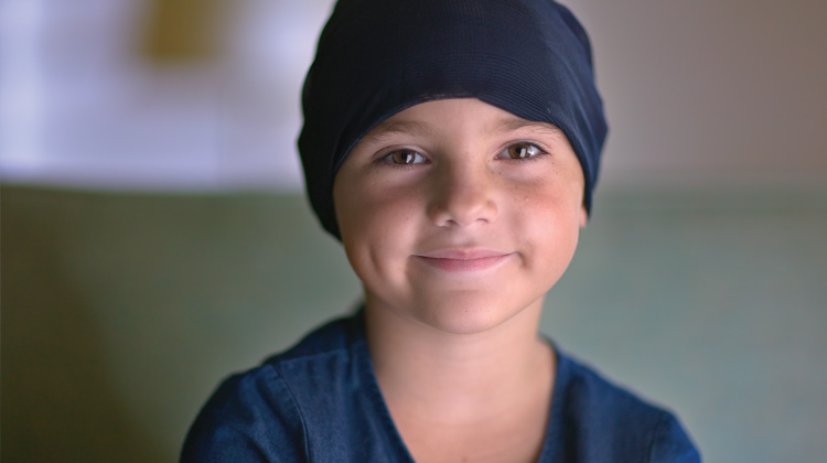 Leukemia patient, Annie, smiles for the camera with bright hazel eyes. click to watch video.