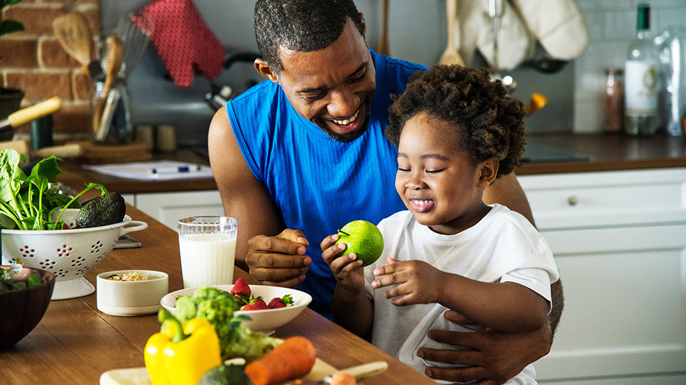 Un padre y su hijo saboreando verduras frescas