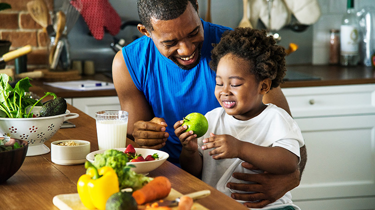 father and child enjoying fresh vegetables
