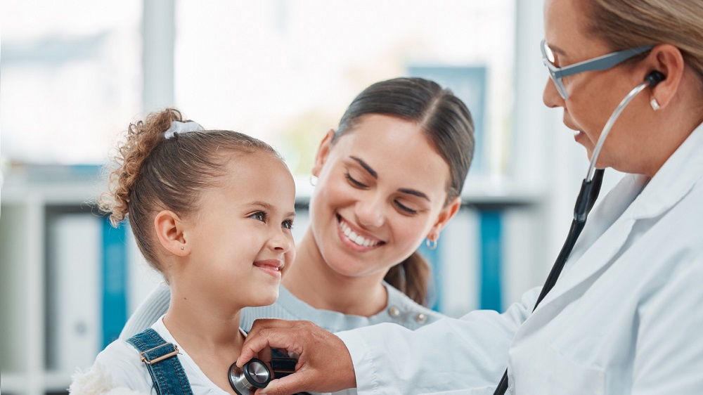 Young girl patient with mother being seen by doctor.