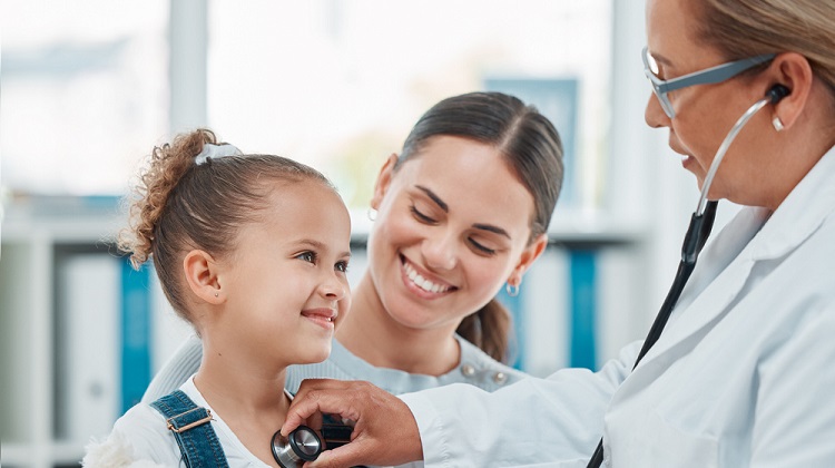 Young girl patient with mother being seen by doctor.