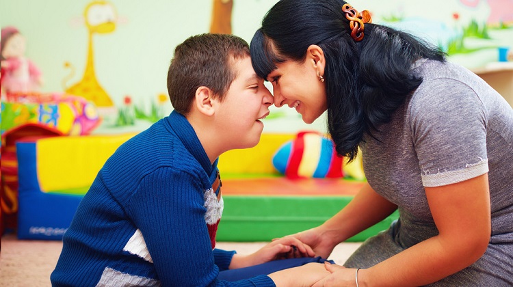 Son with movement disorder with mom in therapy.