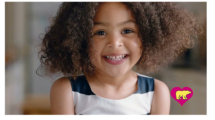 smiling girl with curly hair. click to watch video.