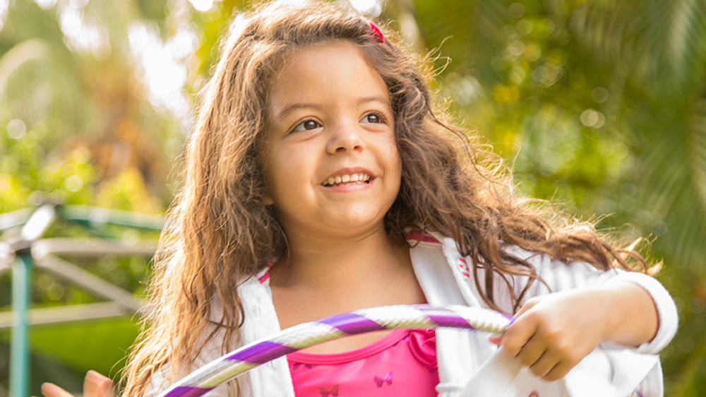 girl with caramel colored hair smiling in the sunlight.