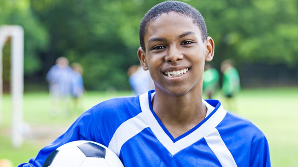 african american boy holding soccer ball