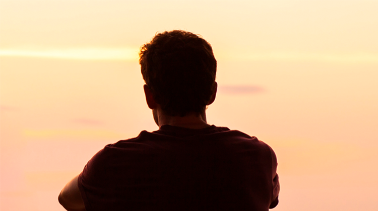teenage boy looking at sunset