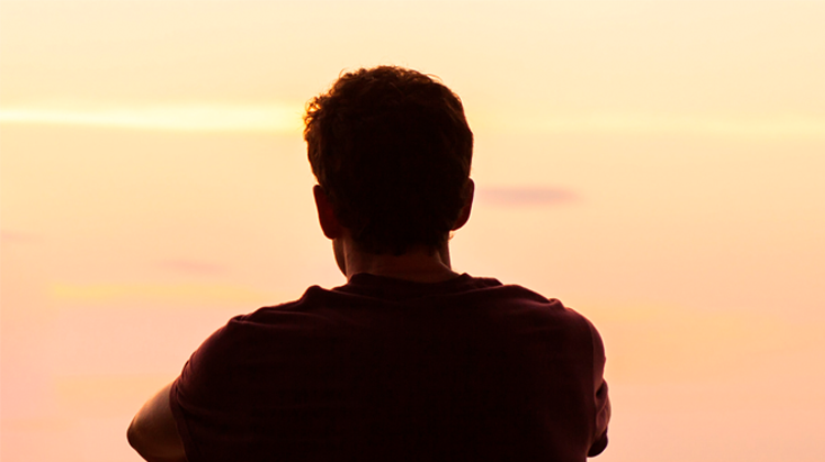 joven mirando al atardecer.