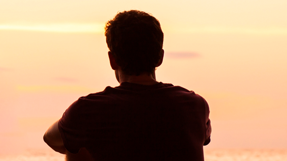 teenage boy looking at sunset