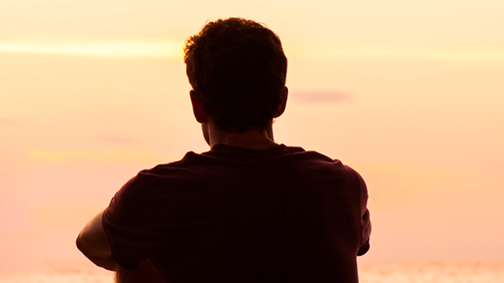 joven mirando al atardecer.