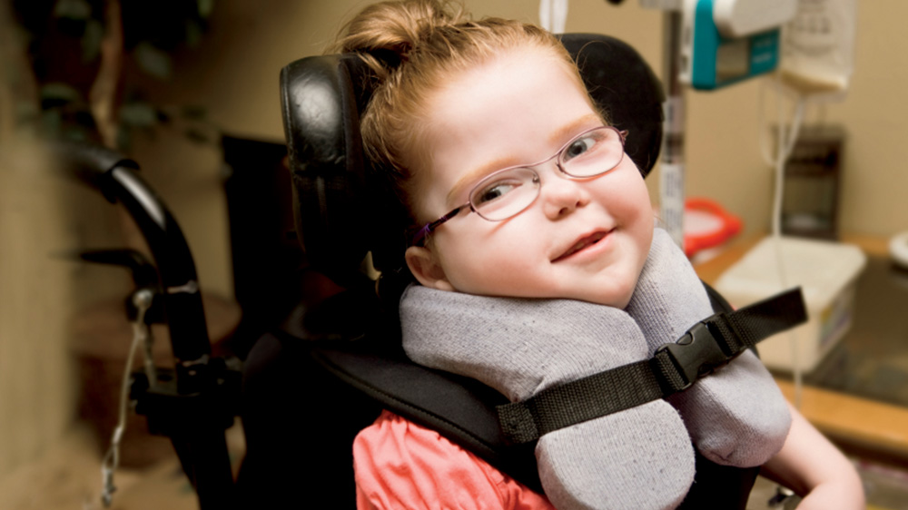 girl in neck brace and special wheelchair