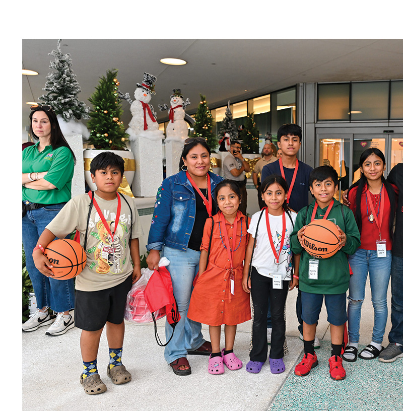 large family holding sporting gifts.