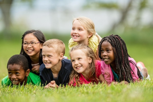 diverse children laying on grass