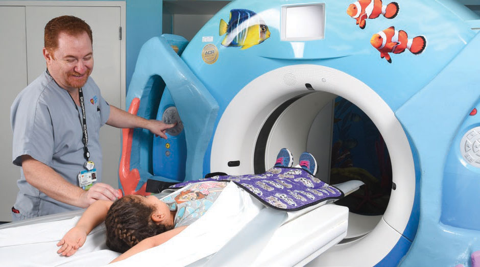 technician easing a girl into ct scanner.