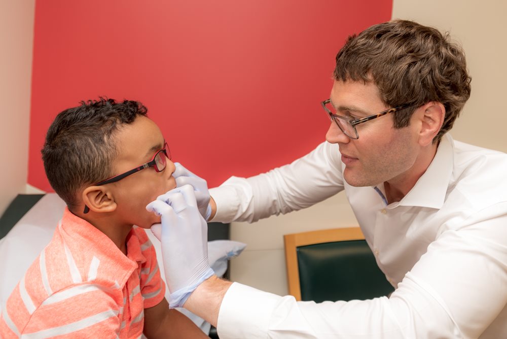 Dr. Sanders examining young boy's teeth.