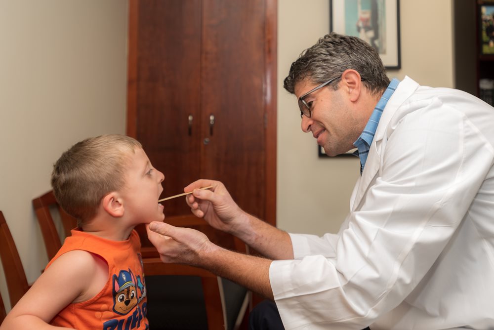 Dr. perlyn examines a young boy's mouth.