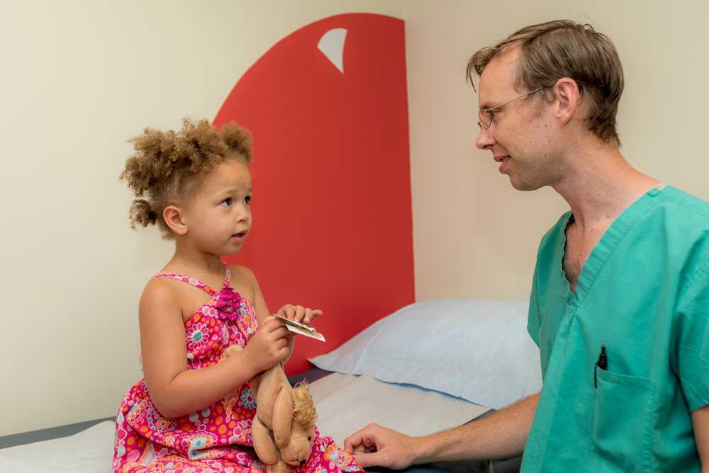 Dr. examining curly haired girl.