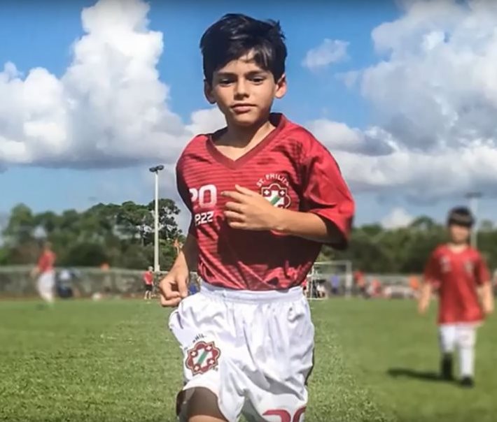 Luife wearing a soccer uniform running on a field. 