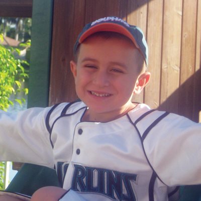 Hunter outside smiling while wearing a baseball cap.