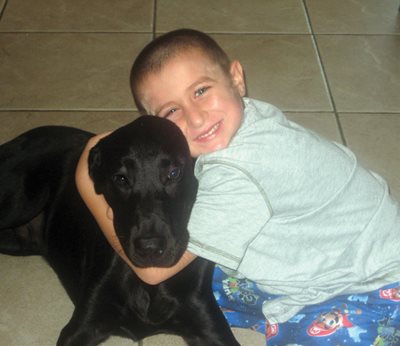 Hunter hugging a large black dog.