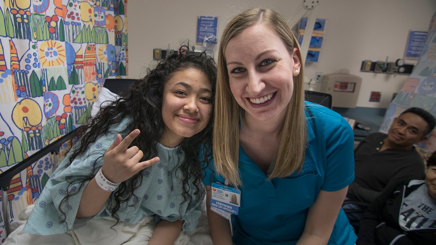 Tonaly in her hospital bed next to Lisa her Child life specialist. 