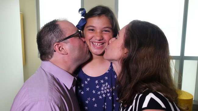 Anabella getting a kiss on each cheek from her mom and dad. 