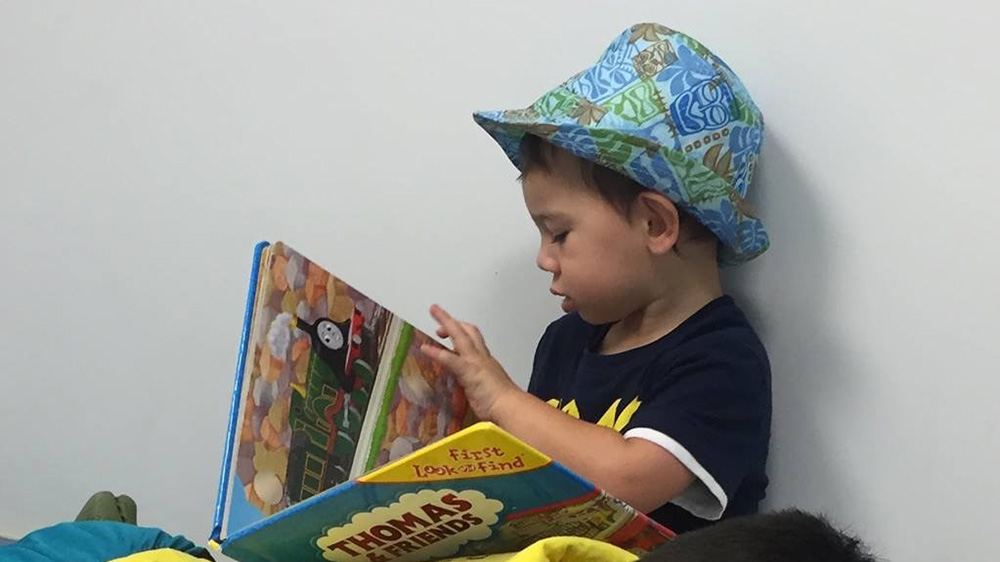 Joshua reading a Thomas and Friends book. 