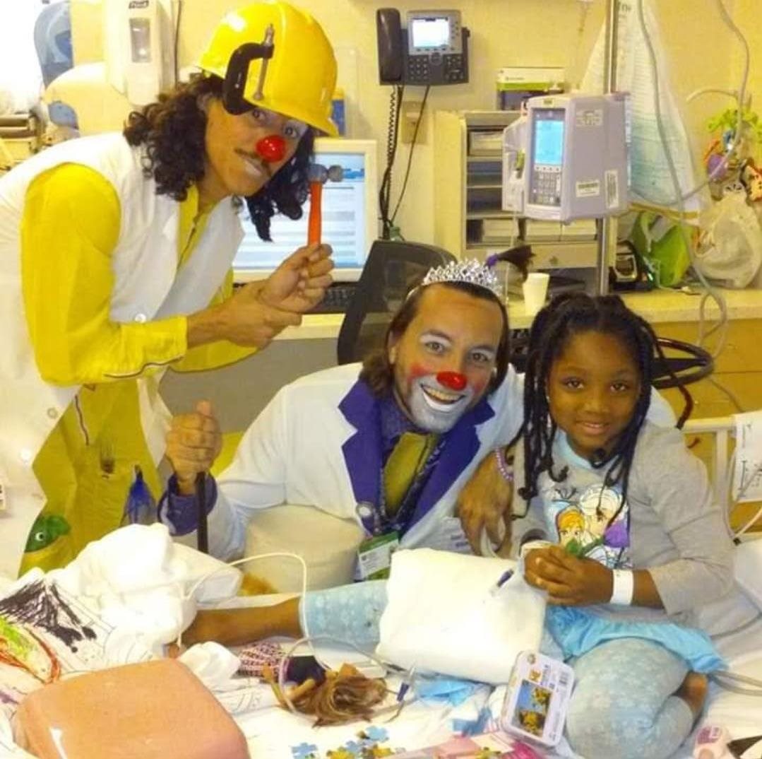 Deja in the her hospital bed playing with clowns.