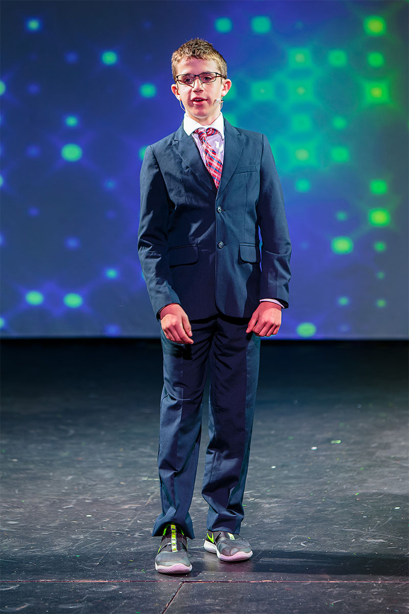 a dapper Beckett in suit and tie during a theatrical presentation.