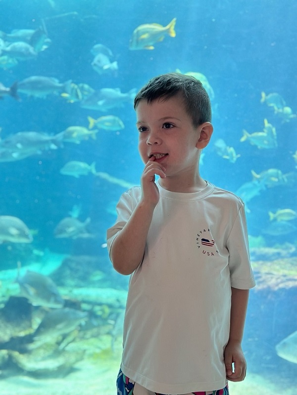 Patient Noah in front of aquarium fish tank