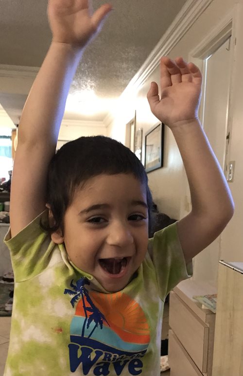 Toddler Emet with his arms raised