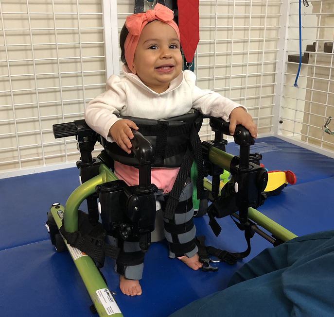 Gianna receiving physical therapy while smiling.