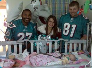 Gianna being visited by Miami Dolphin players and cheerleader