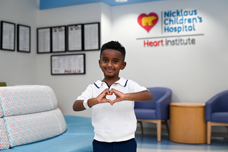 Jamie smiling, making a heart with his hands