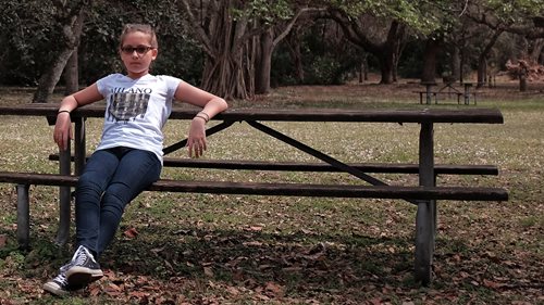 Kira sitting in a park bench