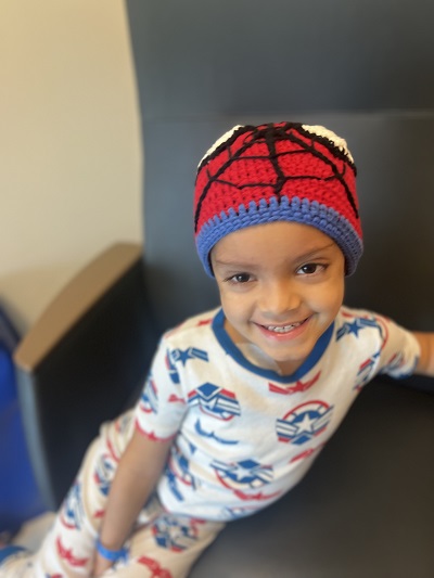 Santiago in pjs and spiderman beanie smiling.