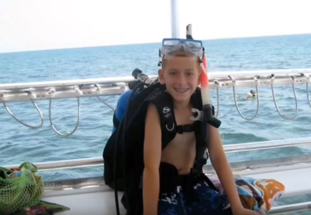 Thomas wearing scuba diving gear on a boat