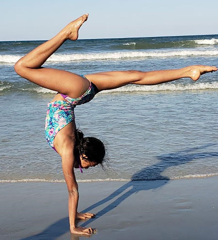 Allison doing a hand stand on the beach