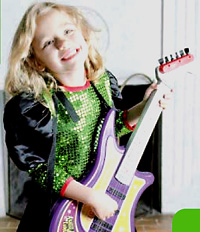 Christina wearing a pop star costume playing a purple toy guitar. 
