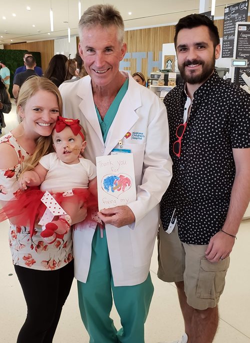 Heidi and her parents standing with Dr. Redmond Burke