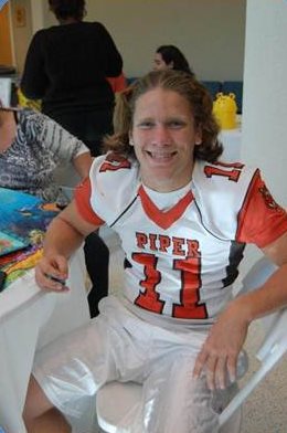 Jesse wearing a orange and white football jersey. 