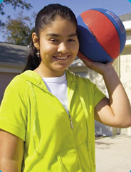 Ruby holding a blue and red basketball in her left hand.