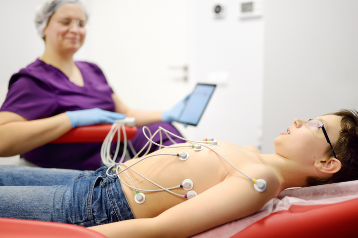 boy laying down on exam chair with electrodes on his body.