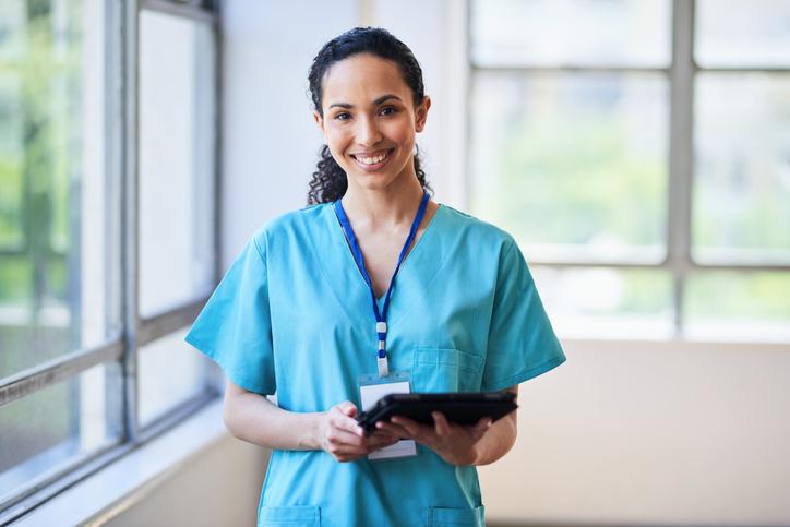 confident female doctor holding tablet.