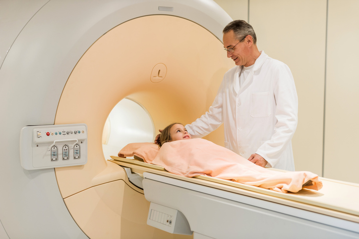 Radiologist smiling down at girl before she enters MRI.