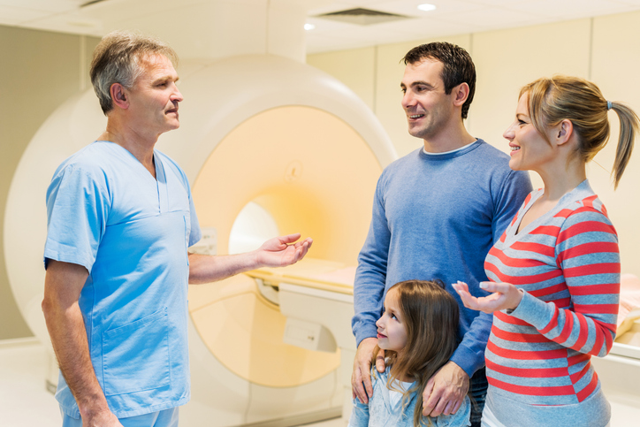Tech talking to parents and child before MRI.